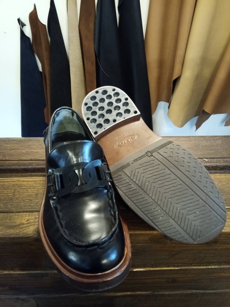 トッズ ローファー 修理 横浜トッズのレディースローファー修理前の状態。トップリフトが摩耗し、ヒールの角が削れて滑りやすくなっている。釘留めがなく外れやすい構造のため、補強交換が必要な状態。