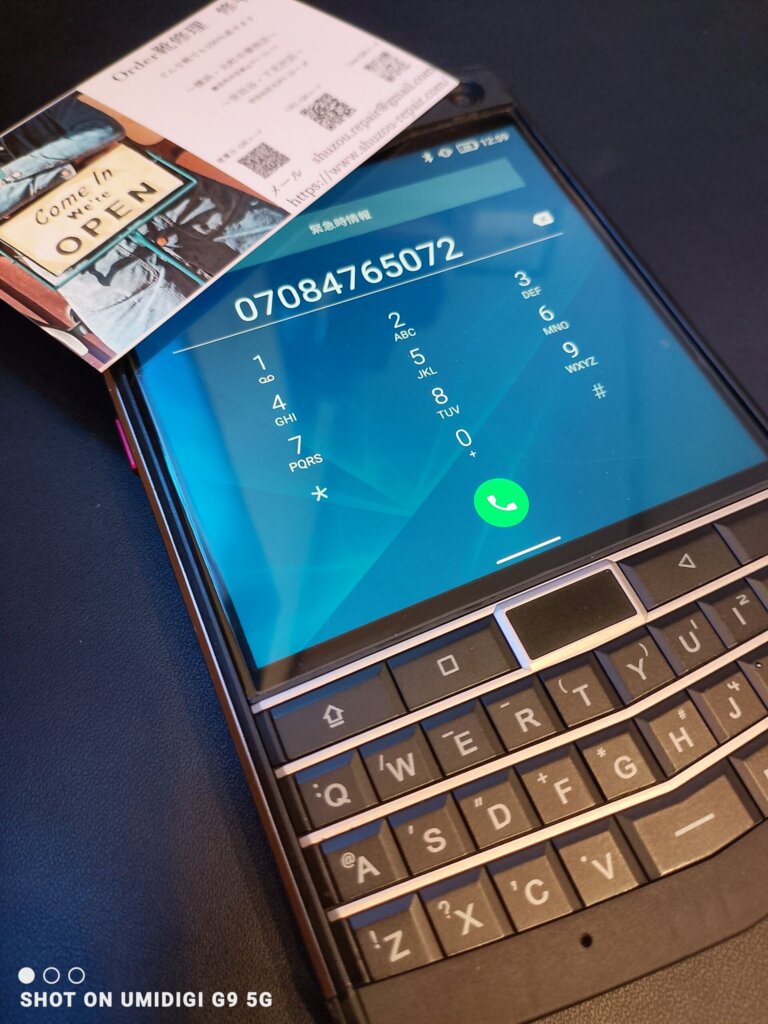 横浜 山手 靴修理専門店Order靴修理修平の電話予約イメージ。店舗連絡先070-8476-5072が表示されたスマートフォンとショップカードの写真。