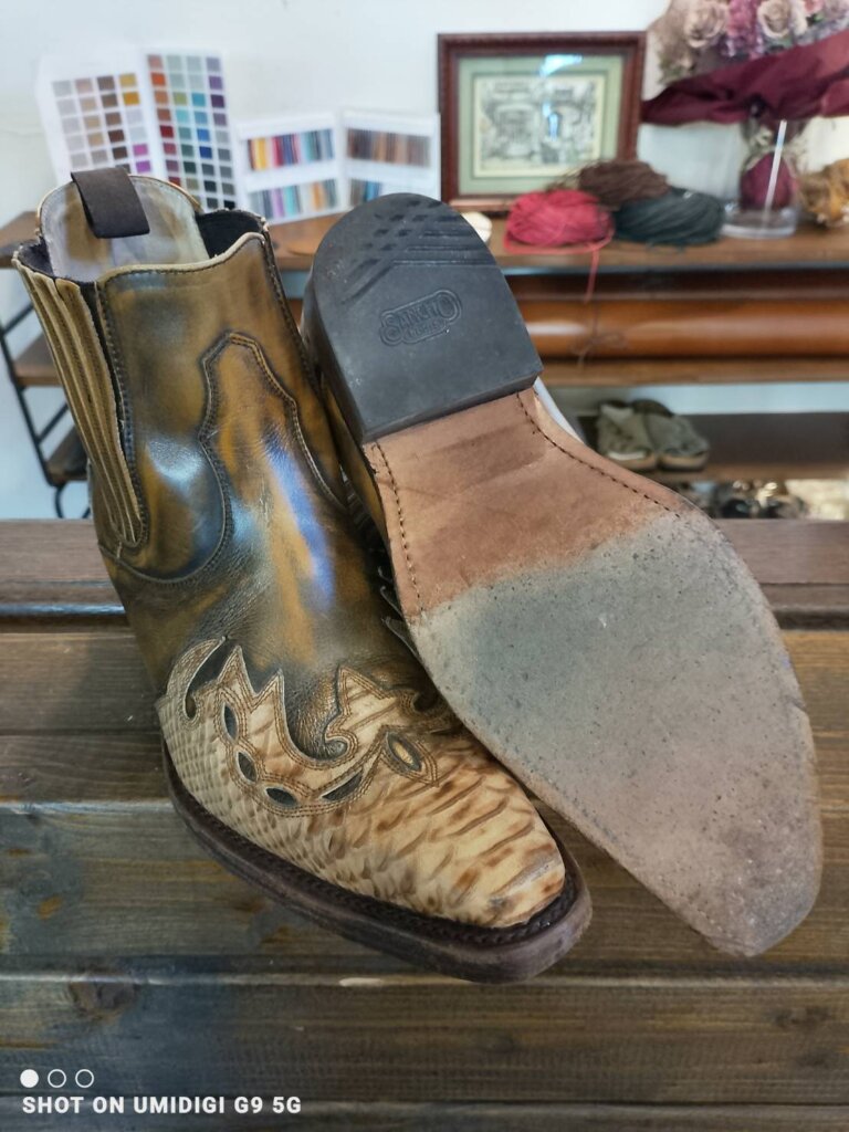 「ウエスタンブーツのかかと削れとレザーソールの摩耗を写したビフォー写真。片足を持ち上げてソールの擦り減り具合が分かるように撮影。」