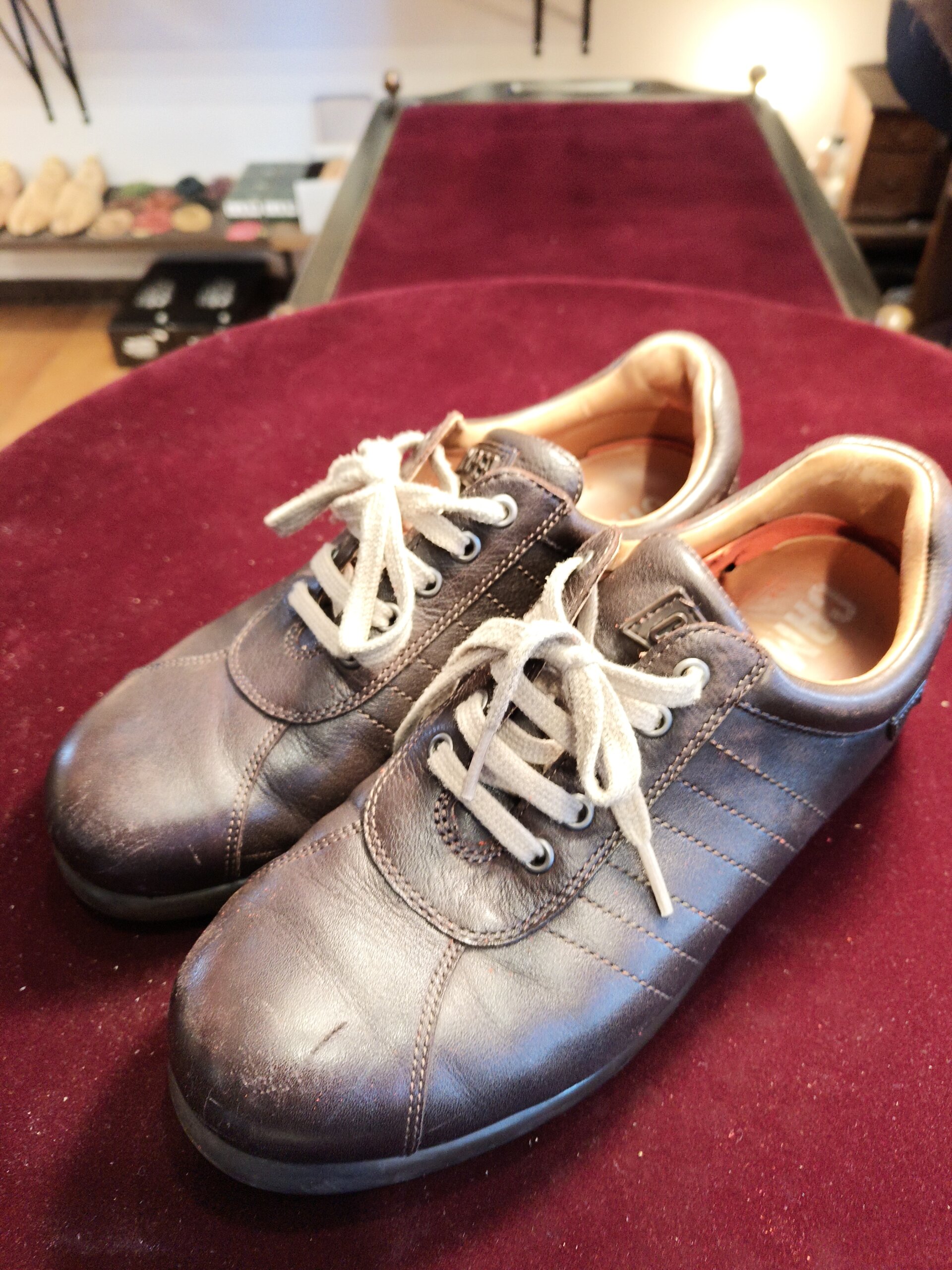 カンペールの中敷き交換修理前のこげ茶色レザースニーカーを斜め前から撮影した写真