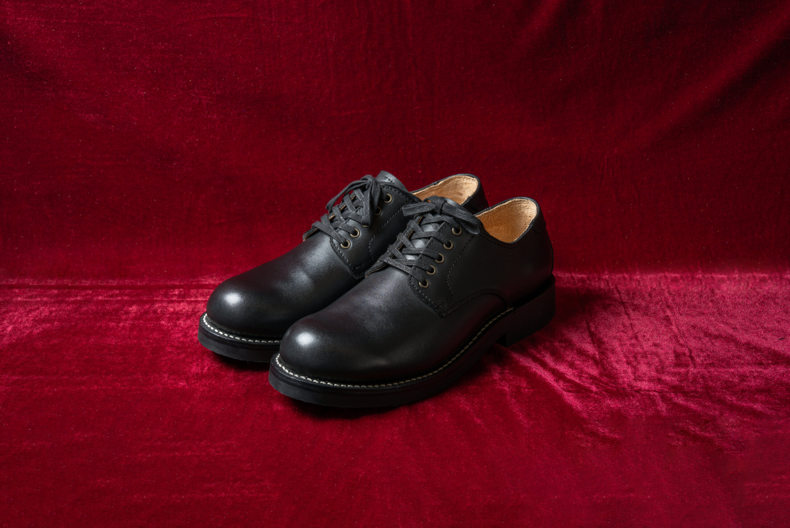 BOOTS SHOP YOKOHAMAの1st model JOJOL 赤いベルベット上で撮影した黒革プレーントゥシューズ